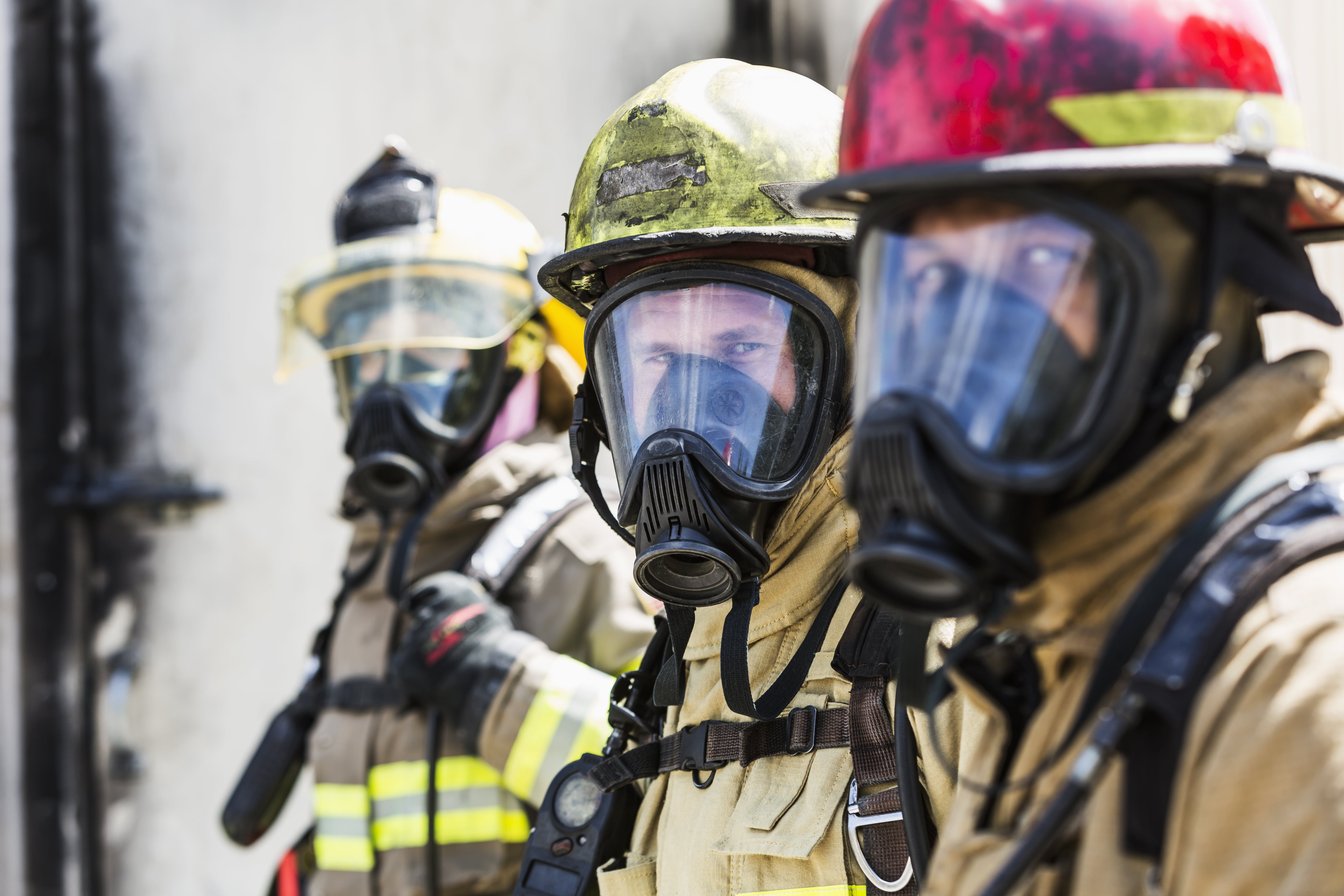 Three firefighters wearing oxygen masks
