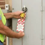 Worker applying lockout tag to electrical panel switch for safety