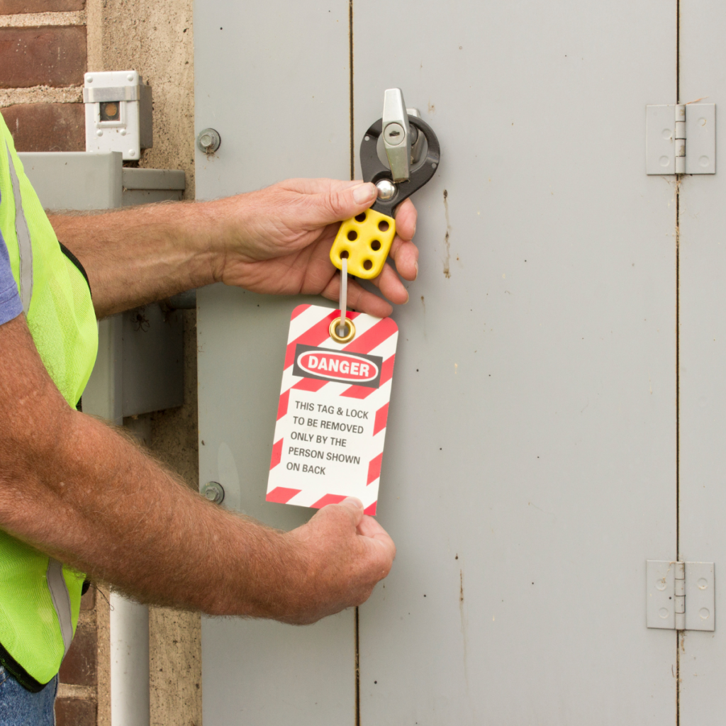 Worker applying lockout tag to electrical panel switch for safety