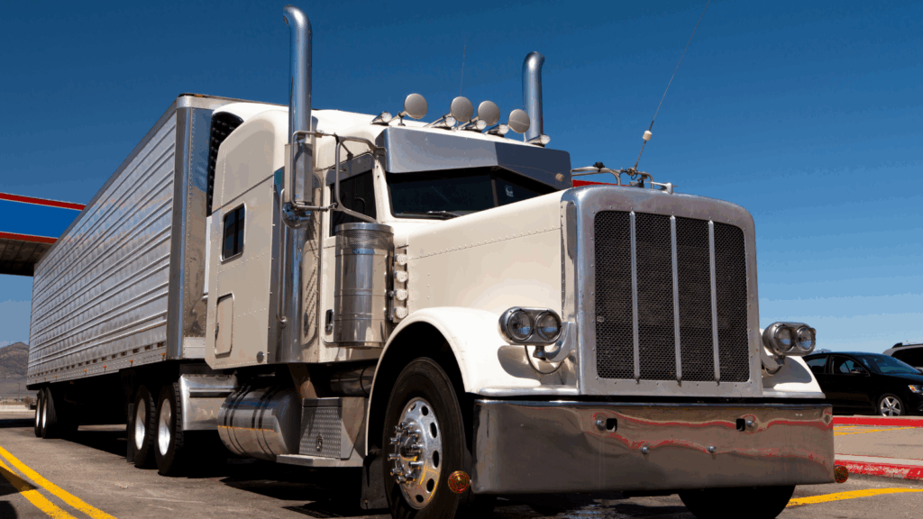 White semi truck with trailer parked under clear blue sky