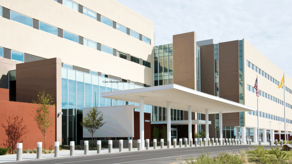 Modern Medical Office Building A contemporary healthcare facility with glass-fronted entrances and a covered drop-off area, representing corporate medical services, outpatient care, or occupational health headquarters.