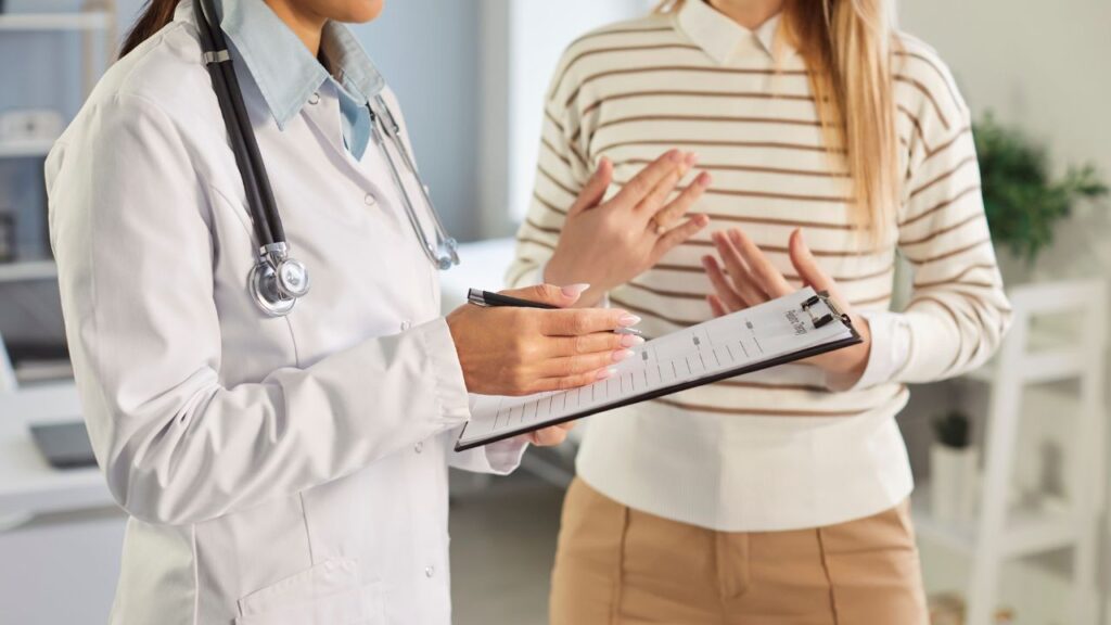 Doctor, holding a clipboard, talking to a patient