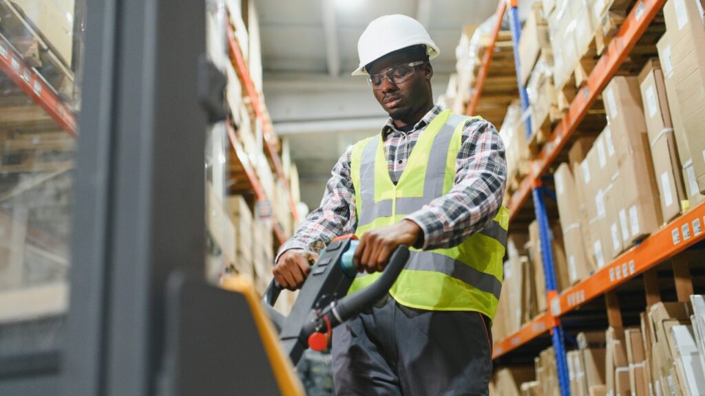 Man working a fork lift in a warehouse