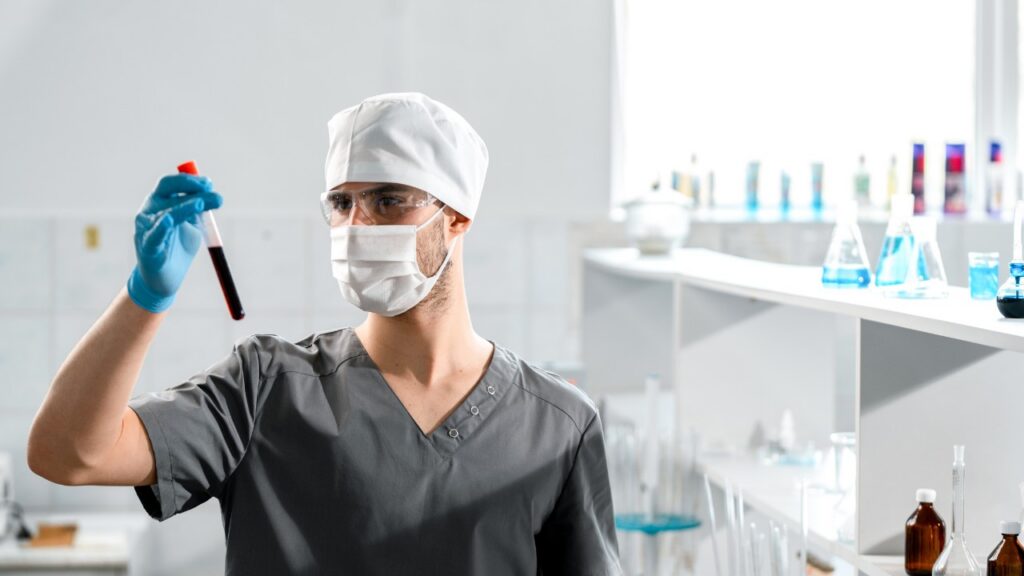 Lab tech reviews blood sample in lab
