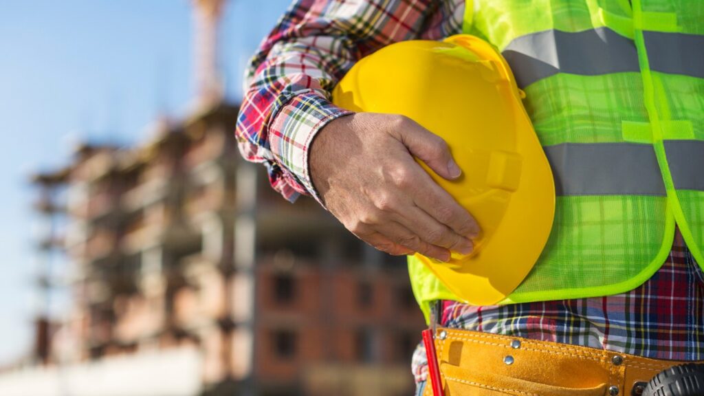 Close up of worker holding a hard hat on construction site